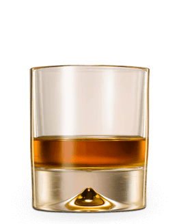 Short clear tumbler filled with one-third amber spirit, featuring a thick base with small inverted conical indentation.