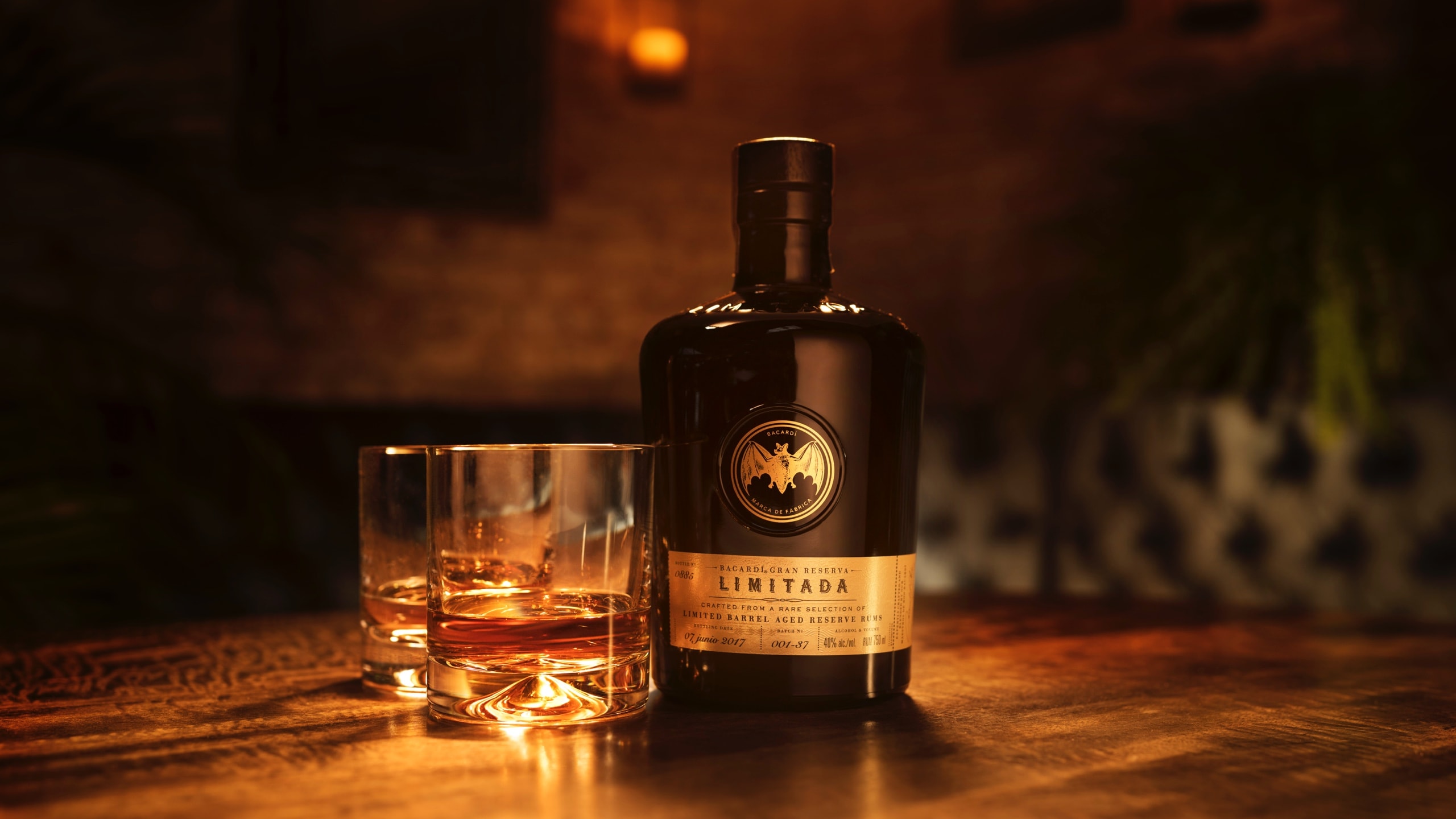 BACARDÍ Gran Reserva Limitada rum bottle with two whiskey glasses of amber rum.