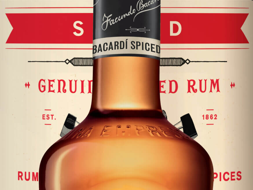 Close-up of Bacardí Spiced rum bottle neck and shoulder with black label.