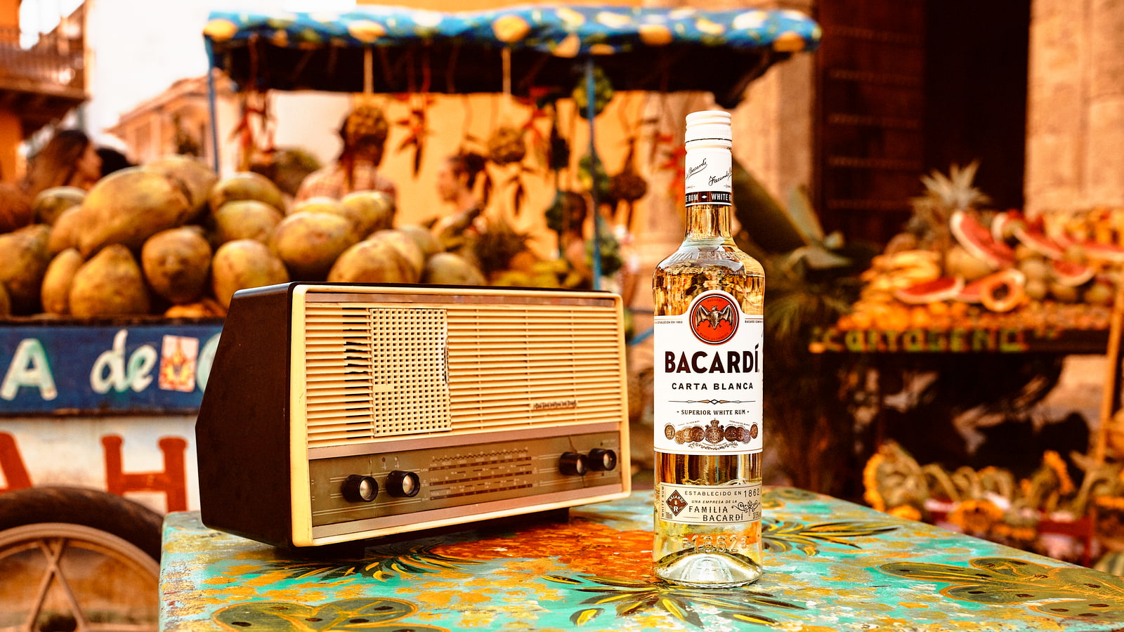 BACARDÍ Carta Blanca rum bottle next to a vintage wooden radio.