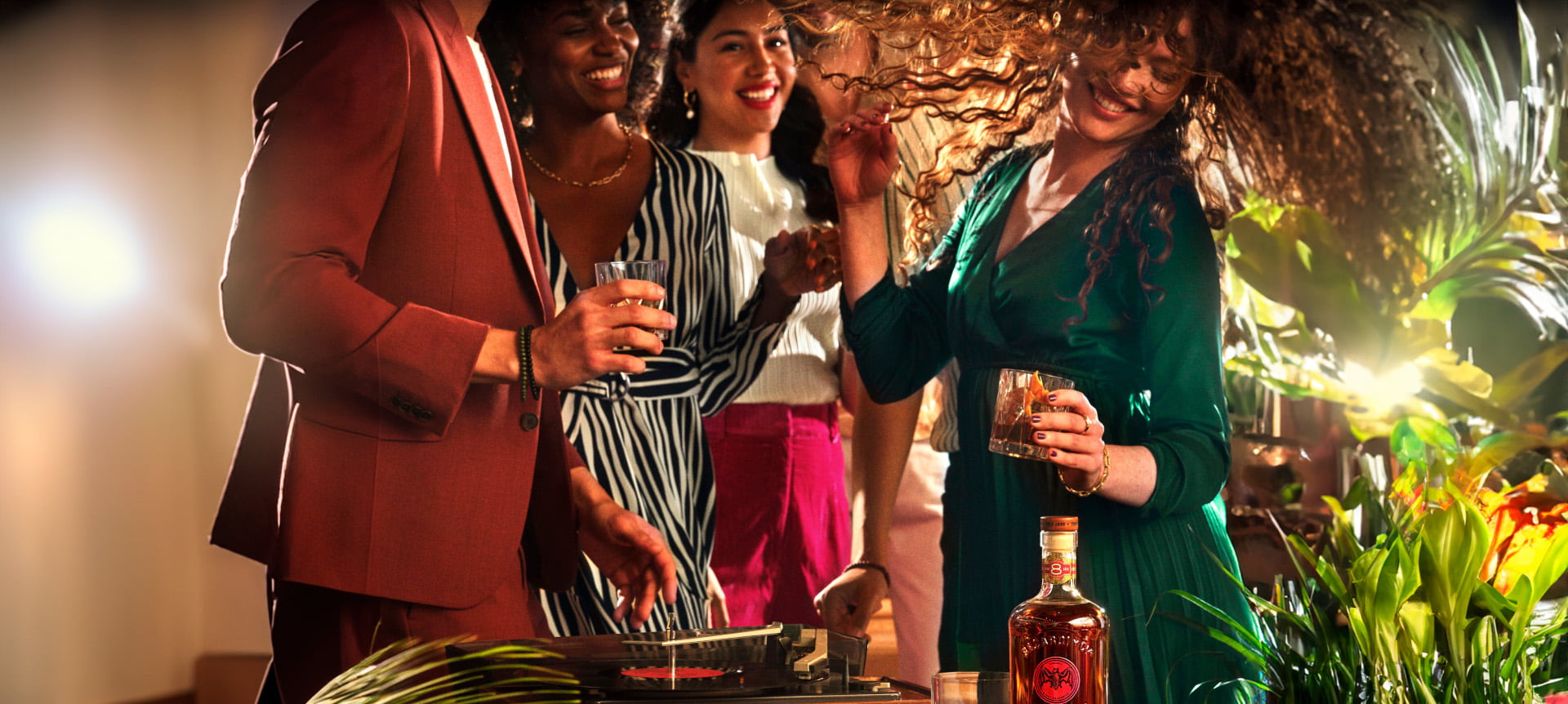 Lively indoor party scene with a rum bottle near a record player, people dancing and holding cocktails.