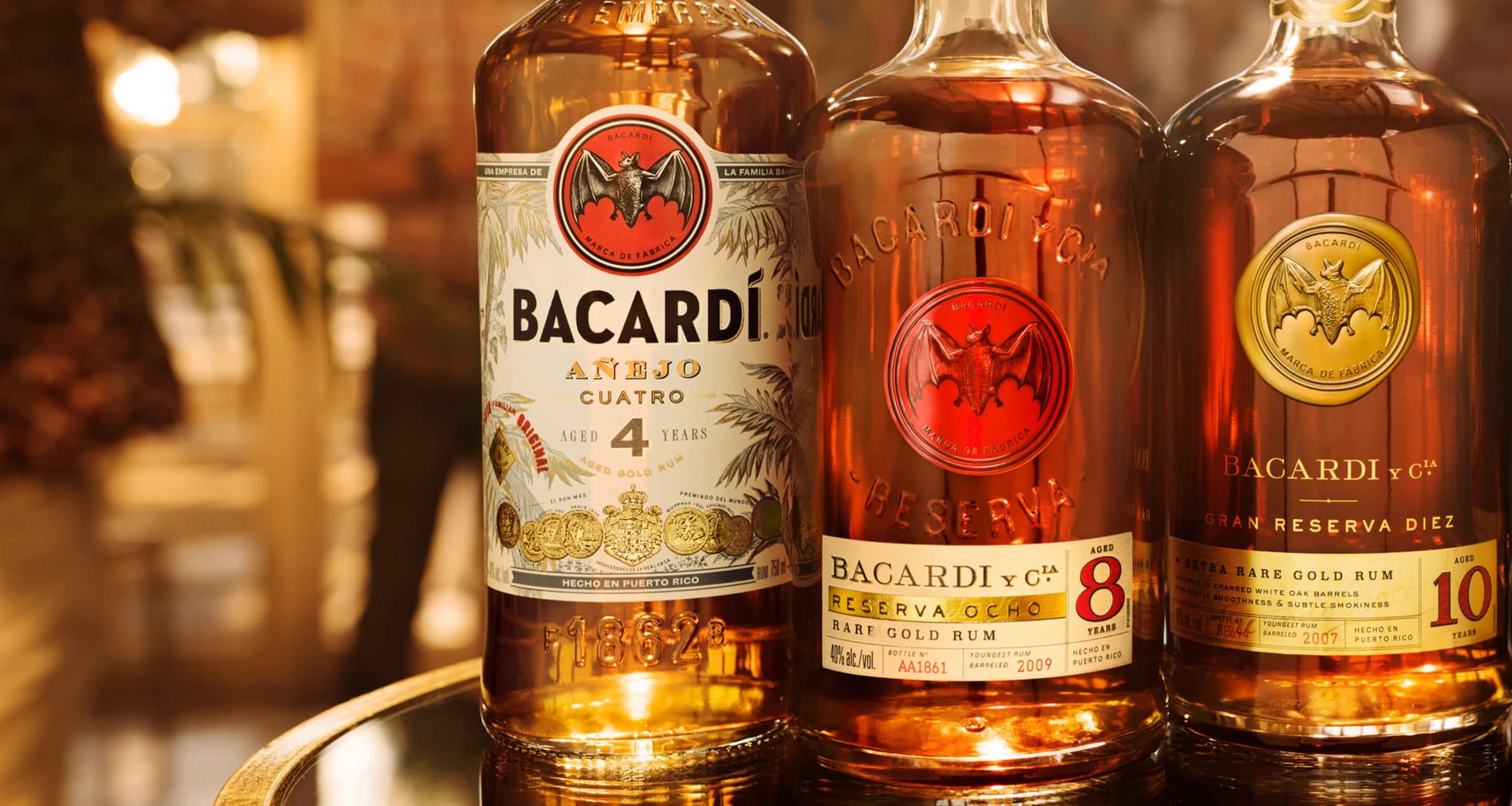 Three BACARDÍ aged rum bottles showcasing Añejo Cuatro, Reserva Ocho, and Gran Reserva Diez variants.