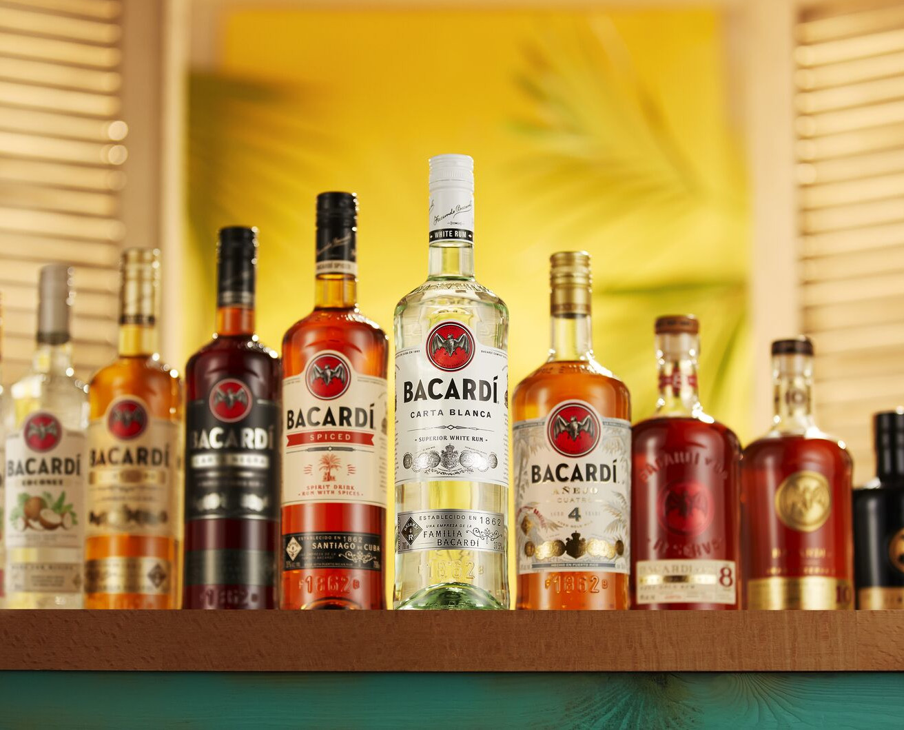 Lineup of BACARDÍ rum bottles including Carta Blanca, Spiced, Black, and aged varieties.