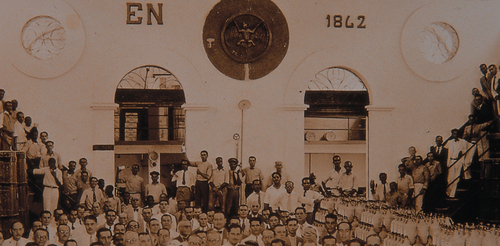 Sepia-toned historical group photograph in a grand hall with high ceilings, dated 1842.