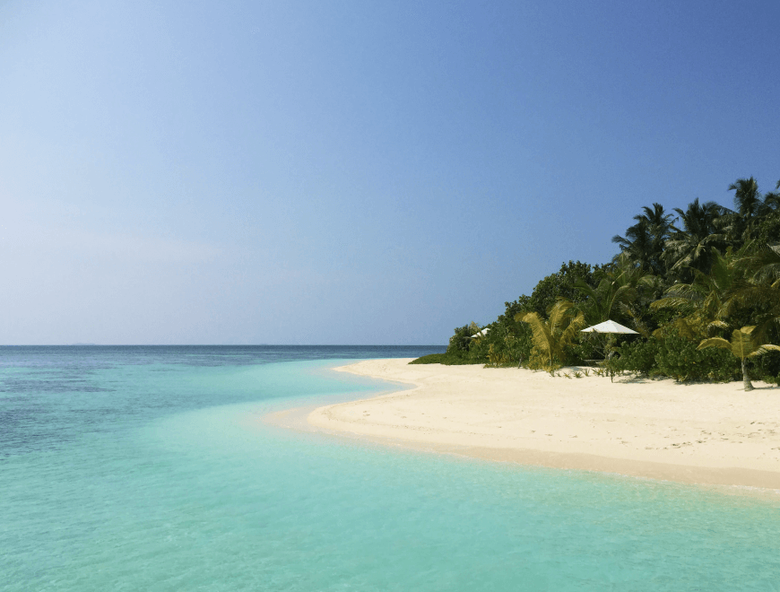 Tropical beach with turquoise water, white sand, palm trees, and a distant white umbrella.
