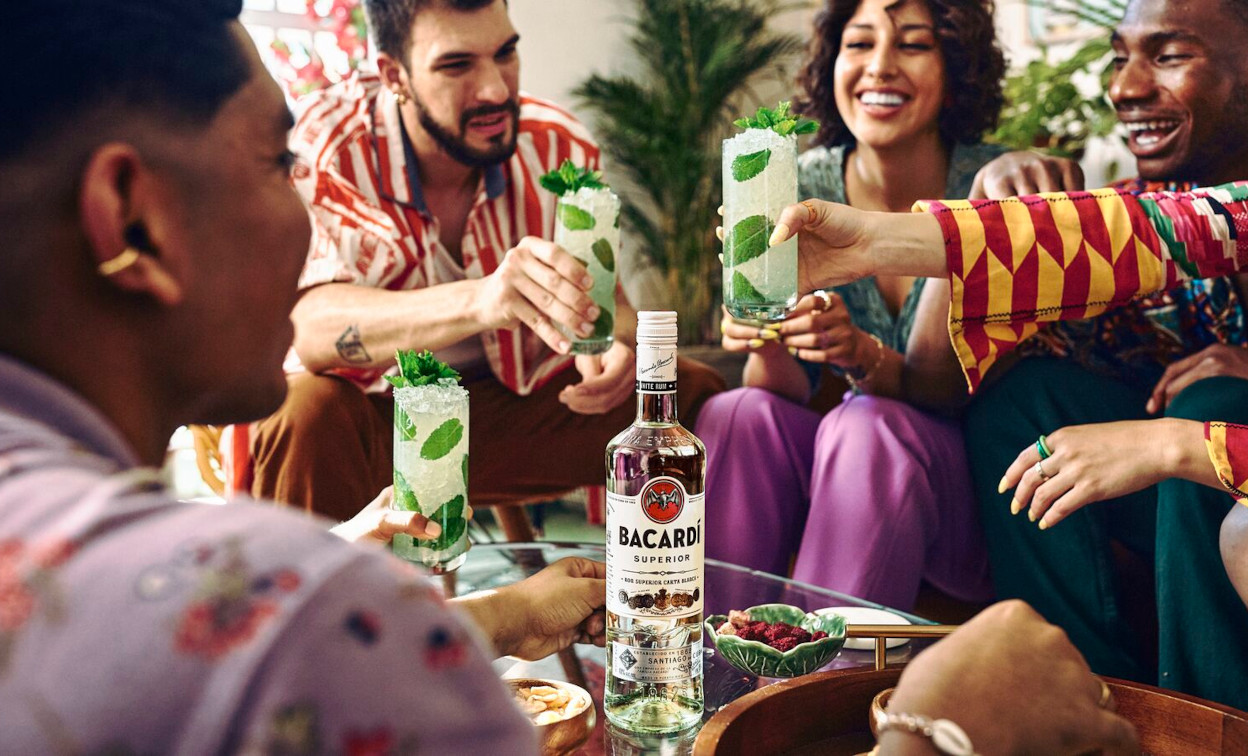 BACARDÍ Superior rum bottle with mojito cocktails on a table.
