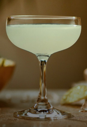 Pale green Daiquiri cocktail in classic coupe glass with soft citrus hints.