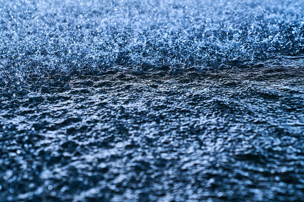 Close-up of water surface with dynamic splashing droplets creating ripples and spray.