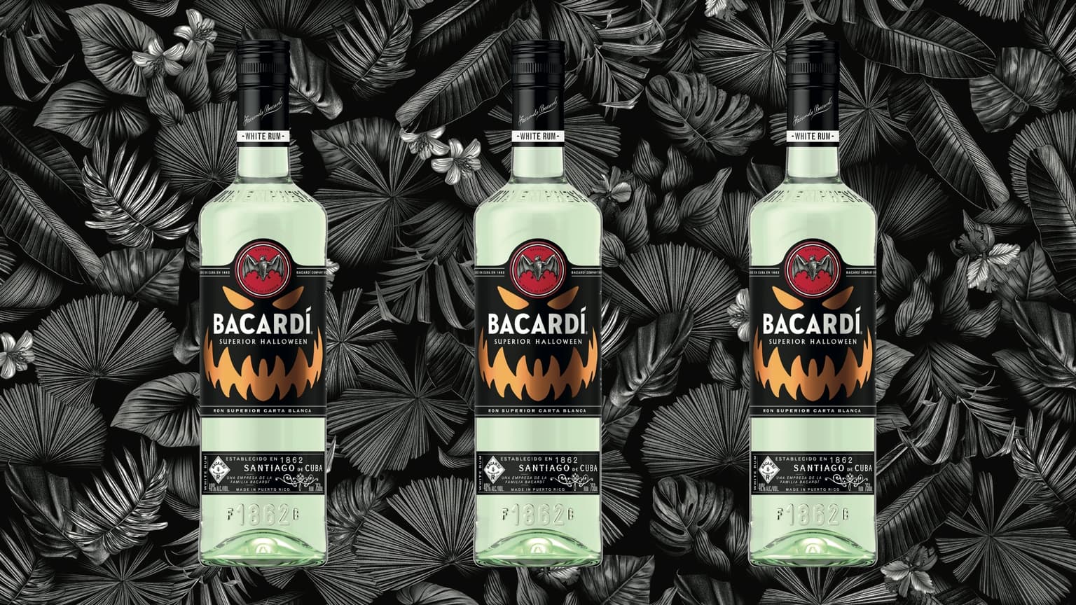Three BACARDÍ Superior Halloween rum bottles with jack-o'-lantern and bat logo labels.