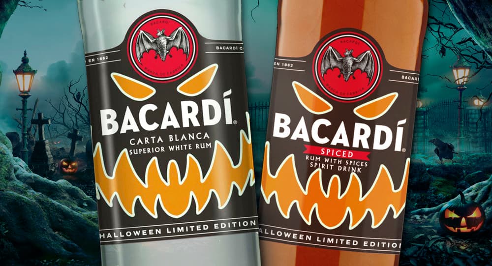 Two BACARDÍ rum bottles with Halloween limited edition labels featuring pumpkin designs.