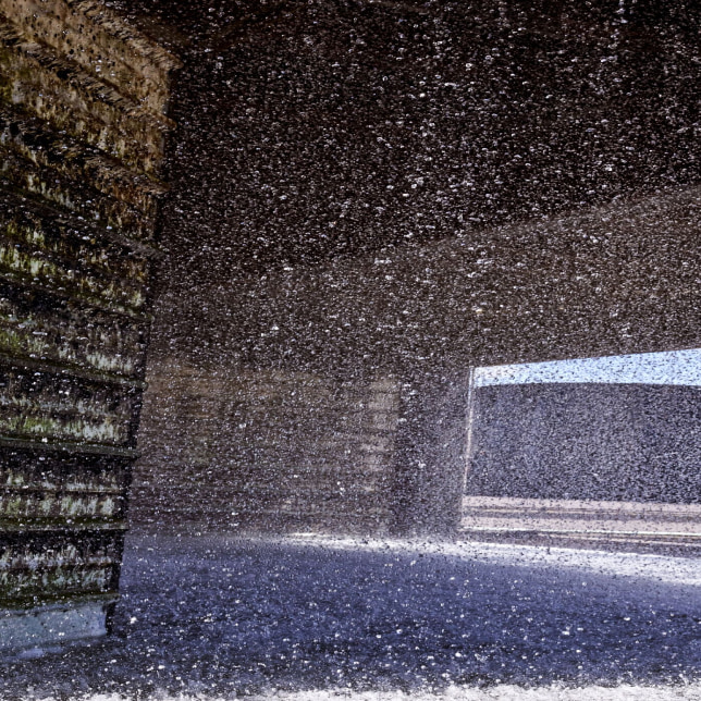 Dynamic scene of water droplets suspended in air, illuminated by distant bright light source.
