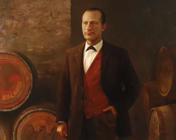 Portrait painting of a man in brown suit, red vest, standing near wooden BACARDÍ barrels.
