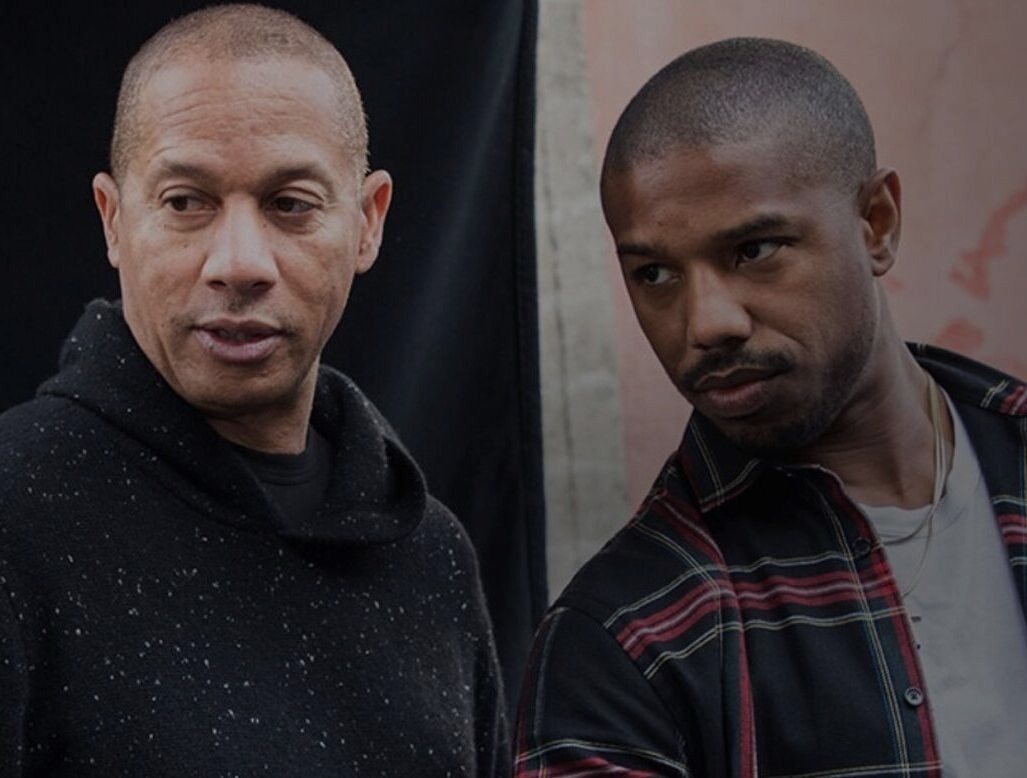 Two people in a portrait, one wearing a dark hoodie looking away, another in a plaid shirt looking down.