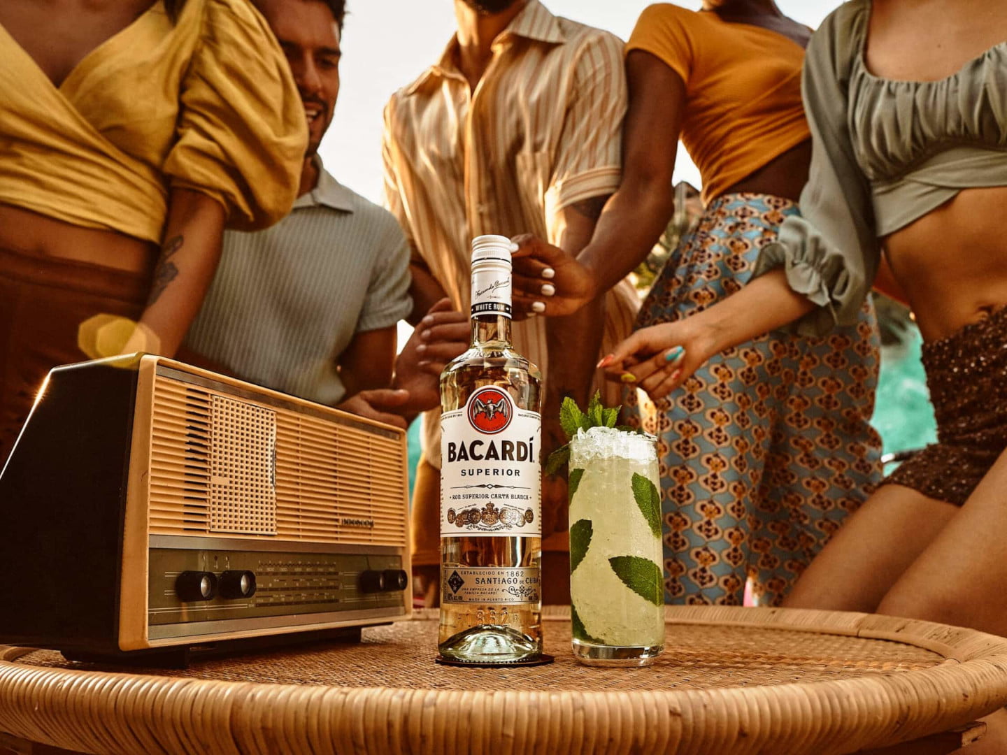 BACARDÍ Superior rum bottle and cocktail with mint and ice near a vintage radio.