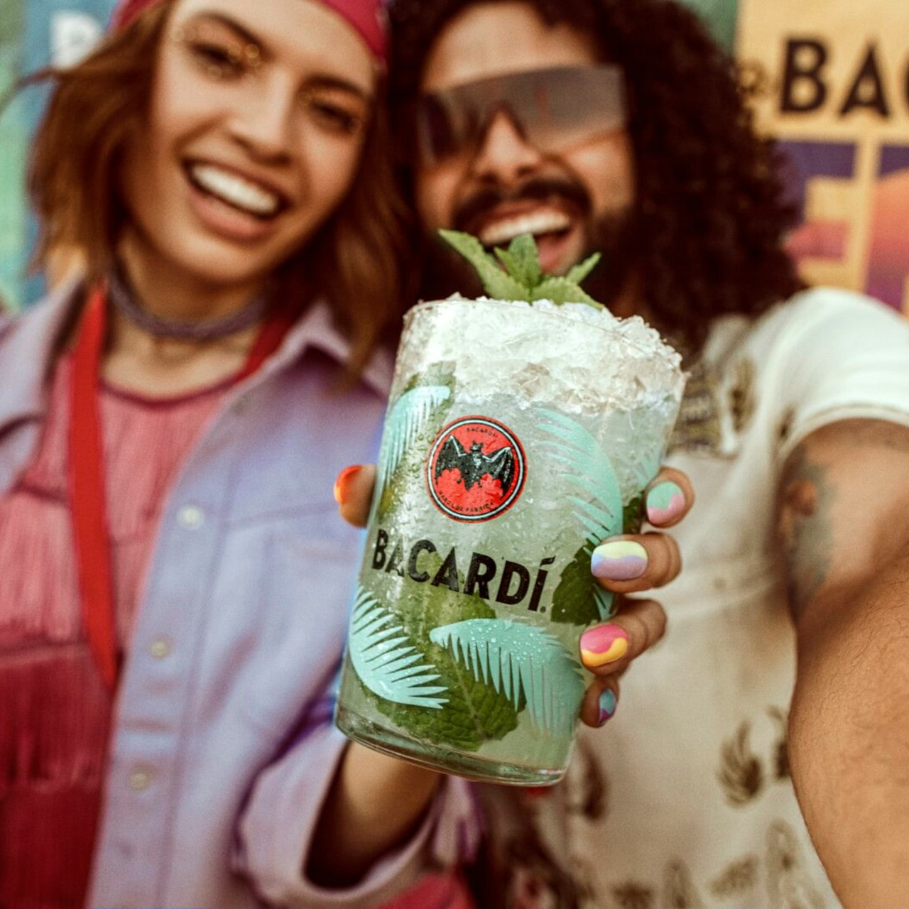 Cocktail glass with crushed ice and mint, held by a hand.